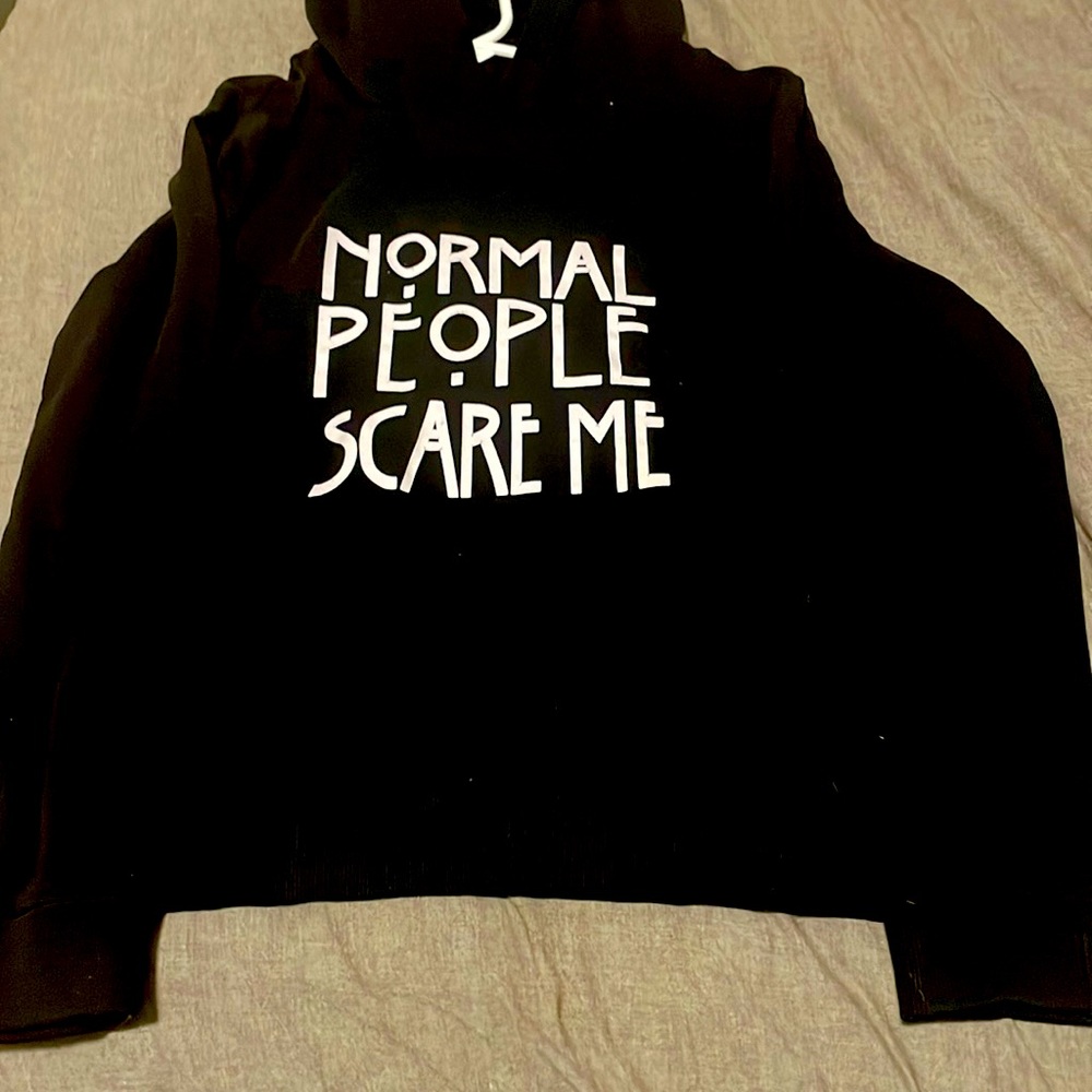 Black black hoodie white bold letters of “normal people scare me”